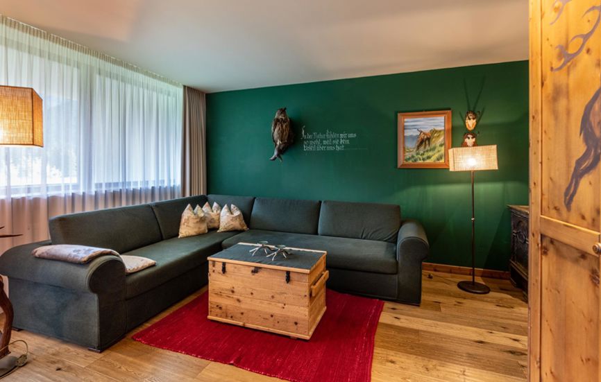 Nel soggiorno della Romantik Suite Lodge dominano i colori rosso e verde