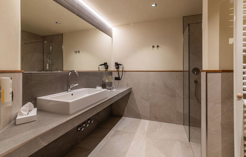 Modernes Badezimmer mit Waschbecken, großem Spiegel und Dusche - Doppelzimmer Landro Lodge
