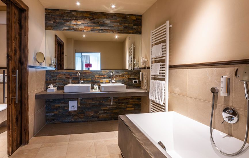 Badezimmer mit Badewanne, zwei Waschbecken und separatem WC - Suite Lodge Saskia