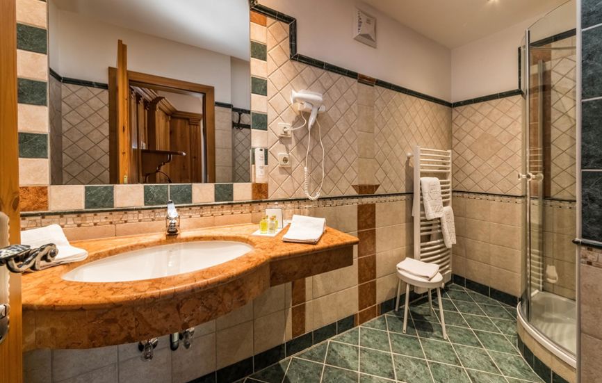 Gefliestes Badezimmer mit Dusche, Waschbecken Spiegel und Fön - Doppelzimmer Alpenrose